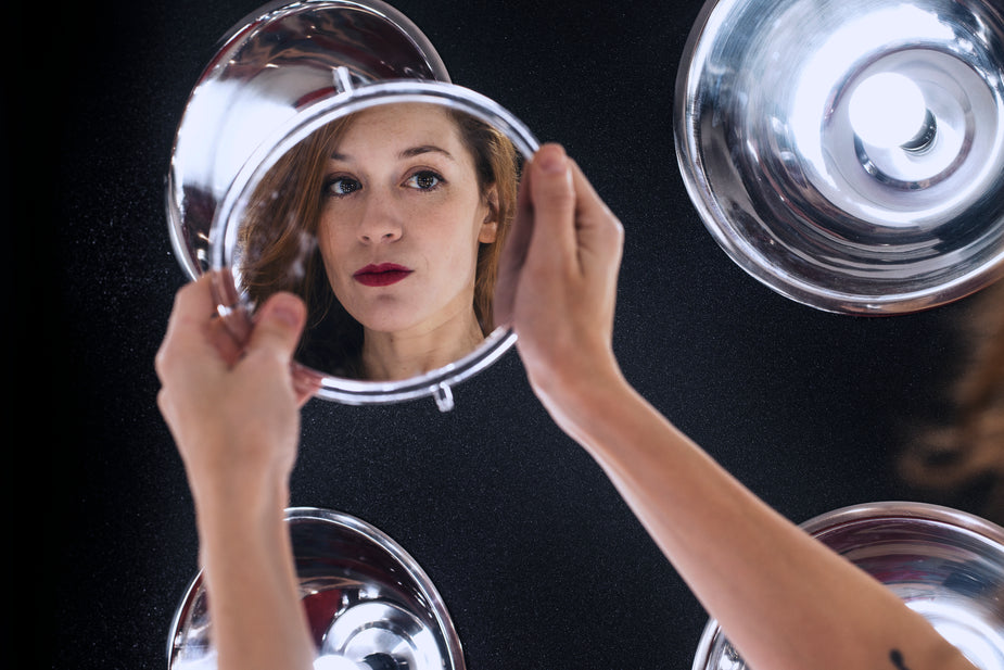 A woman looking at her reflection in the mirror